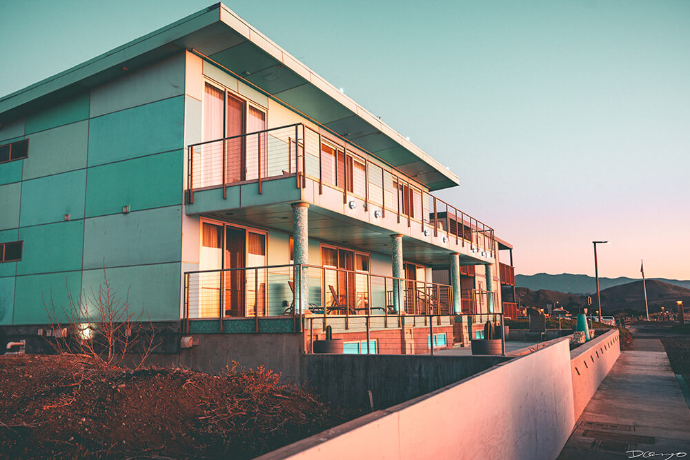 A teal painted house in Pacifica, California, glows in golden sunset.